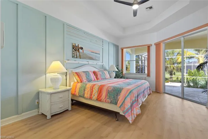 Bedroom featuring a raised ceiling, wood finished floors, and access to exterior