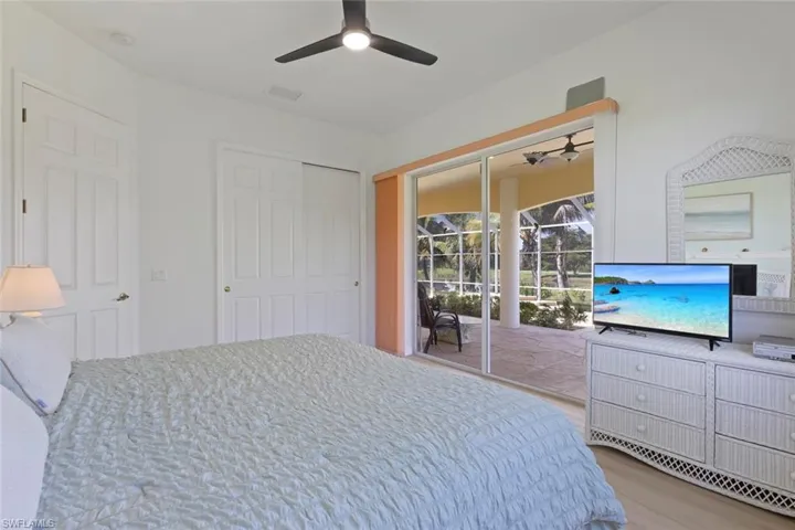Bedroom with light wood finished floors, access to exterior, ceiling fan, and a closet