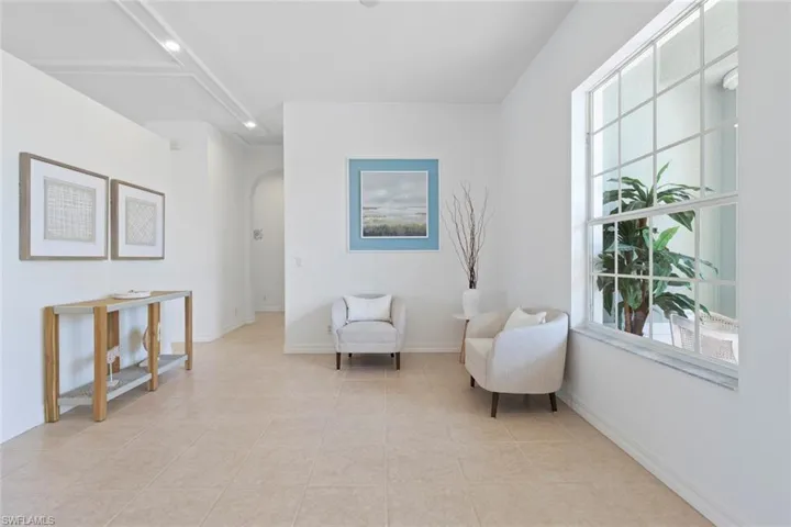 Living area featuring arched walkways and light tile patterned flooring