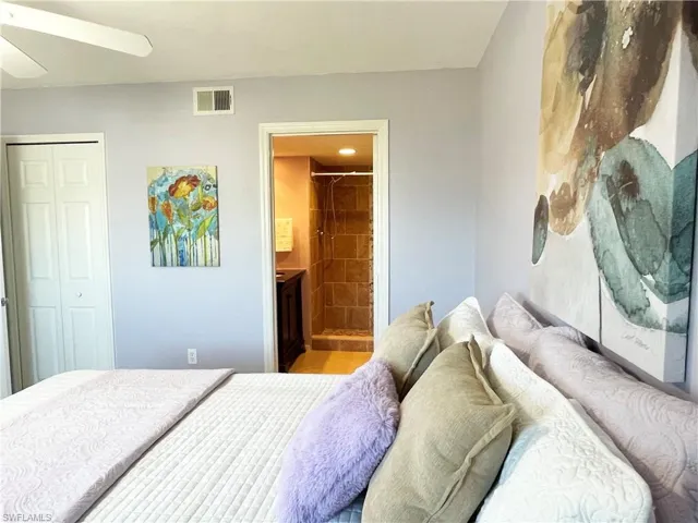 Bedroom with ceiling fan, connected bathroom, and a closet