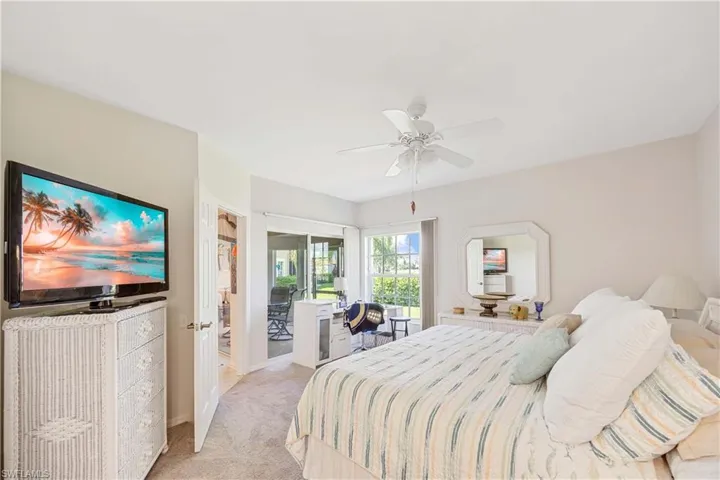 Bedroom featuring light colored carpet, ceiling fan, baseboards, and access to outside