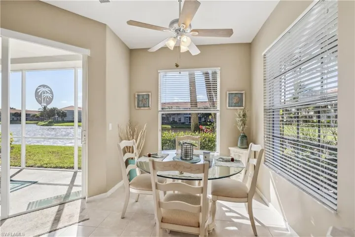 Tiled dining space with a water view, ceiling fan, and a healthy amount of sunlight
