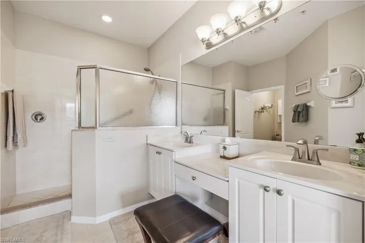 Main bedroom bathroom featuring vanity, tiled shower, and tile patterned flooring