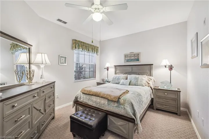 Carpeted guest bedroom with ceiling fan.