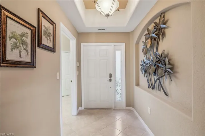 Tiled foyer entrance with a raised ceiling