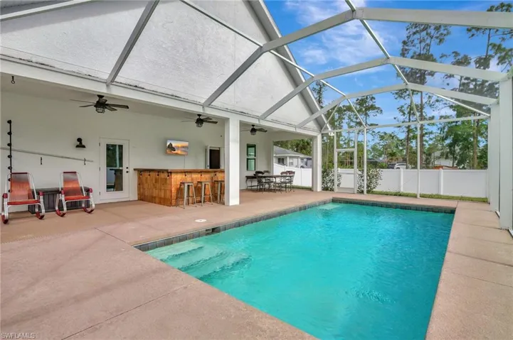 Screened lanai with Heated Pool, Built in Bar, Spacious Sundeck and view of the property