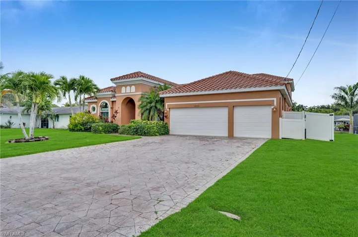 Mediterranean / spanish-style house featuring stucco siding, decorative driveway, a garage, and a tiled roof