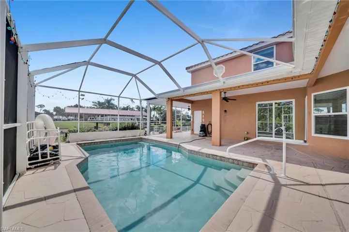 Outdoor pool with a sunroom, a patio area, glass enclosure, and ceiling fan