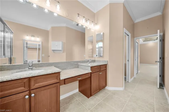 Full bathroom featuring ornamental molding, light tile patterned floors, double vanity, and a closet