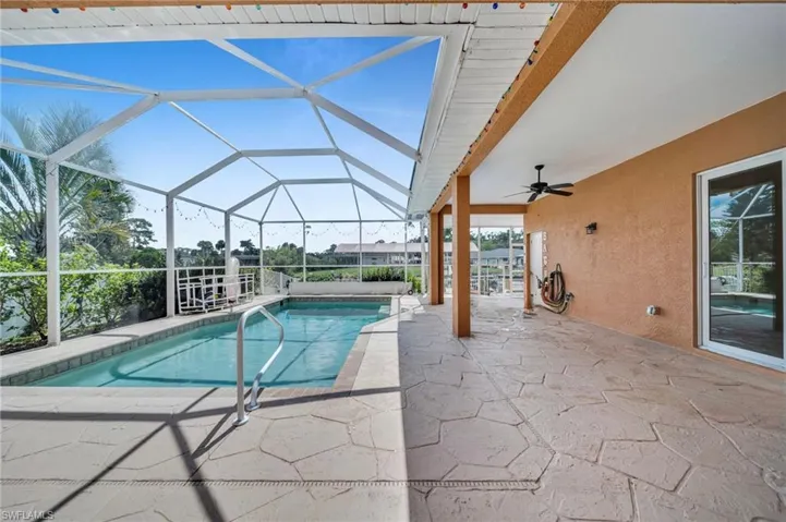 Outdoor pool featuring a patio, a sunroom, ceiling fan, and a lanai