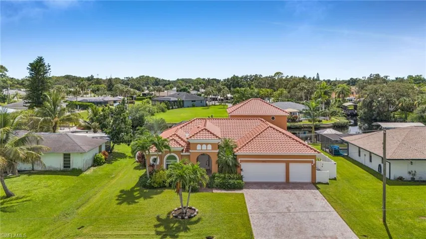 View of front facade featuring a residential view, decorative driveway, a tile roof, and a front lawn