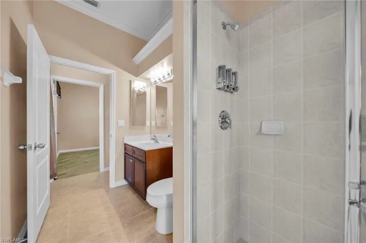 Full bath featuring vanity, ornamental molding, a stall shower, and light tile patterned floors
