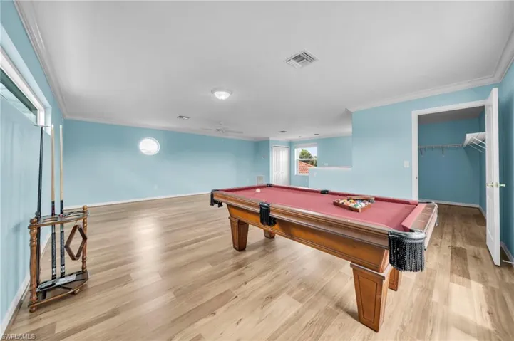 Rec room with billiards, light wood finished floors, crown molding, and ceiling fan
