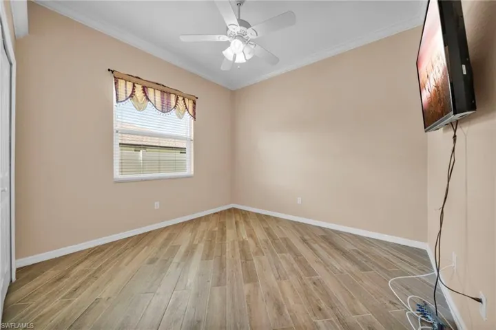 Unfurnished bedroom featuring crown molding, light wood-type flooring, ceiling fan, and a closet