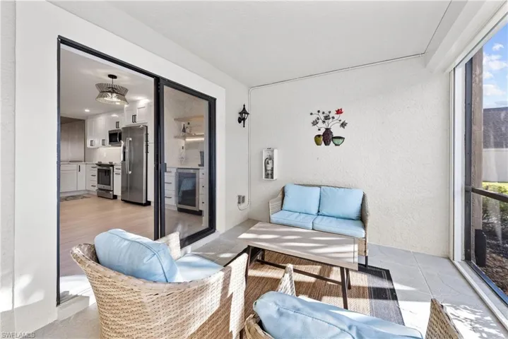 Sunroom / solarium featuring plenty of natural light, an outdoor hangout area, and wine cooler