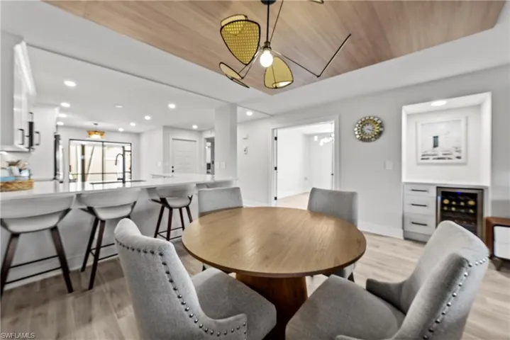 Dining area with wood ceiling, light wood finished floors, wine cooler, recessed lighting, and a ceiling fan