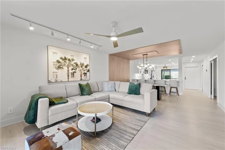 Living area featuring a chandelier, a ceiling fan, and rail lighting