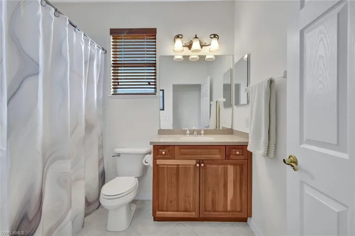 Bathroom featuring vanity, curtained shower, and light tile patterned floors