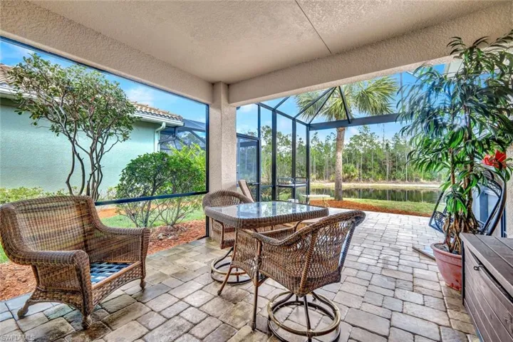 Sunroom with a patio, outdoor dining space, and a water view