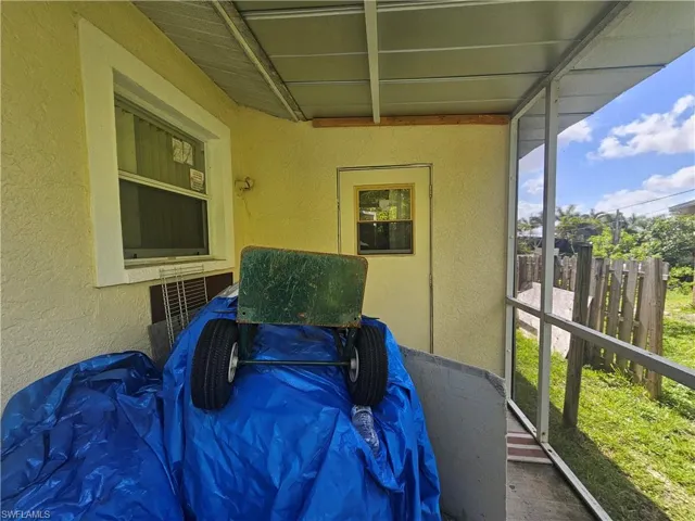 View of side of property featuring a sunroom and stucco siding