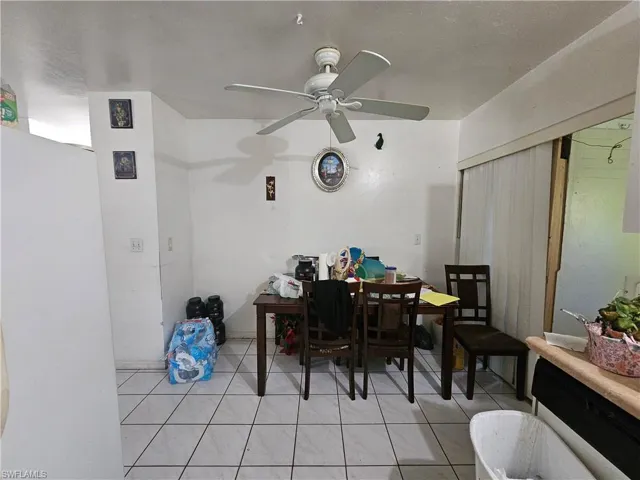 Dining area with a ceiling fan and light tile patterned floors
