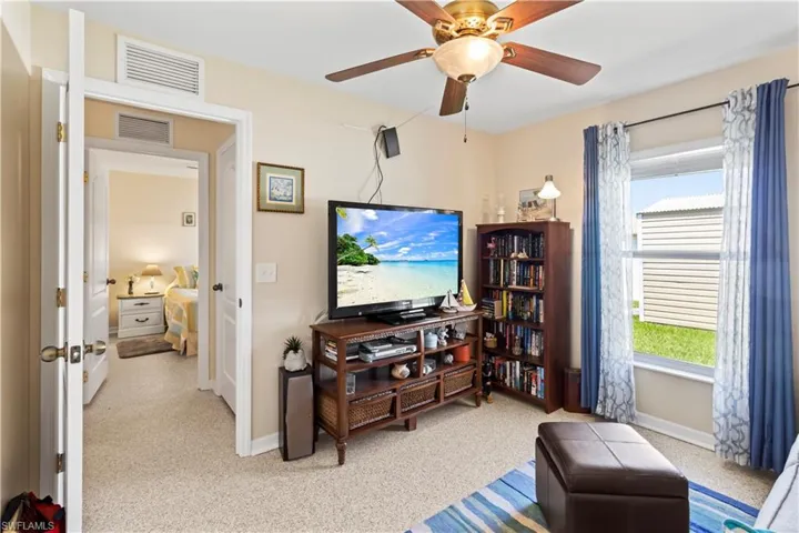 Bedroom with ceiling fan, light carpet, and ensuite bathroom