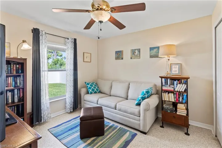 Living area with light colored carpet and ceiling fan