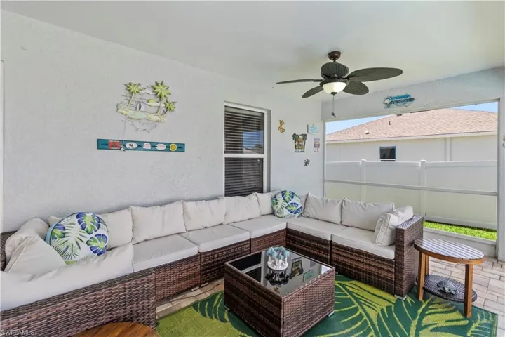 Living area with a ceiling fan and a textured wall