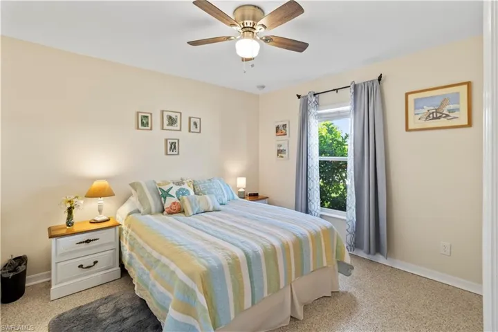 Bedroom with ceiling fan and light carpet