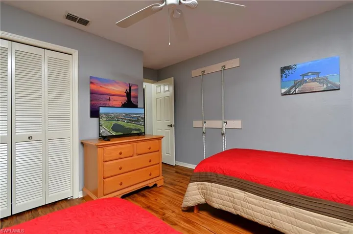 Bedroom with hardwood / wood-style floors, ceiling fan, and a closet