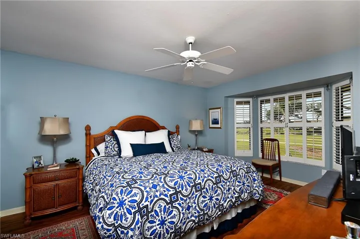 Bedroom with ceiling fan and dark wood-type flooring