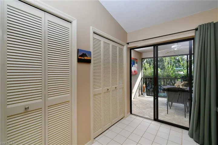 Entryway with ceiling fan, lofted ceiling, and light tile patterned floors