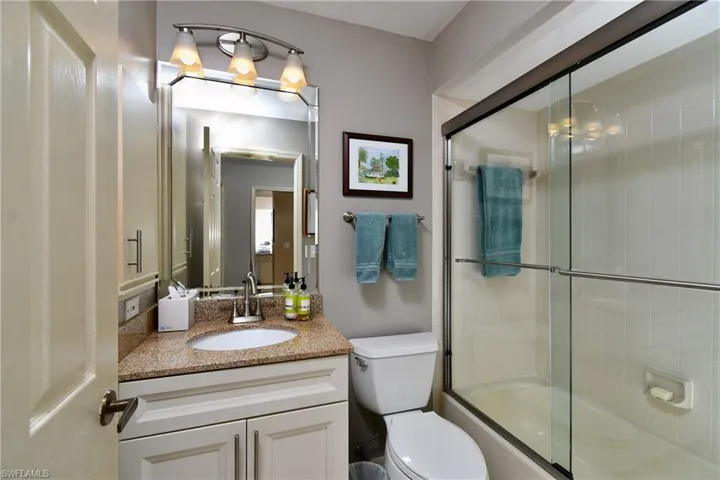 Full bathroom with vanity, toilet, and enclosed tub / shower combo