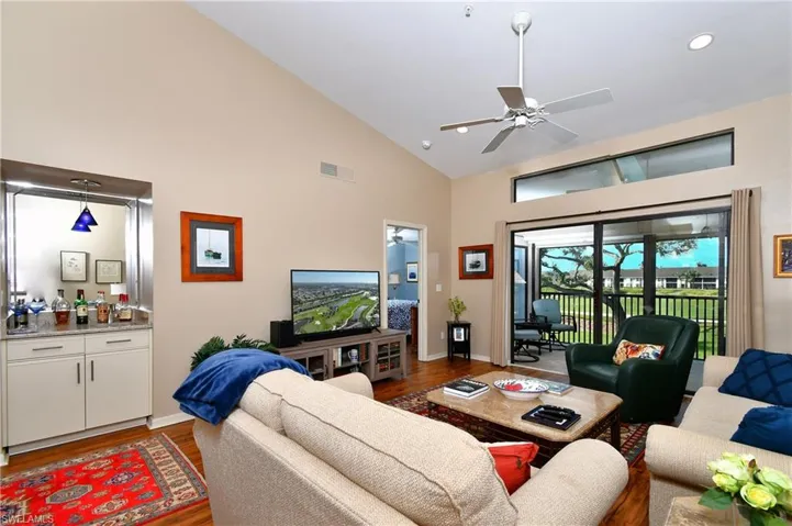 Living room featuring ceiling fan, dark hardwood / wood-style flooring, and high vaulted ceiling