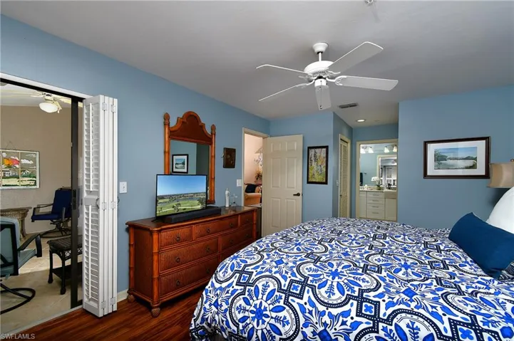 Bedroom with dark hardwood / wood-style flooring, connected bathroom, a closet, and ceiling fan