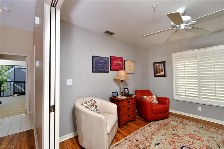 Sitting room with hardwood / wood-style flooring and ceiling fan