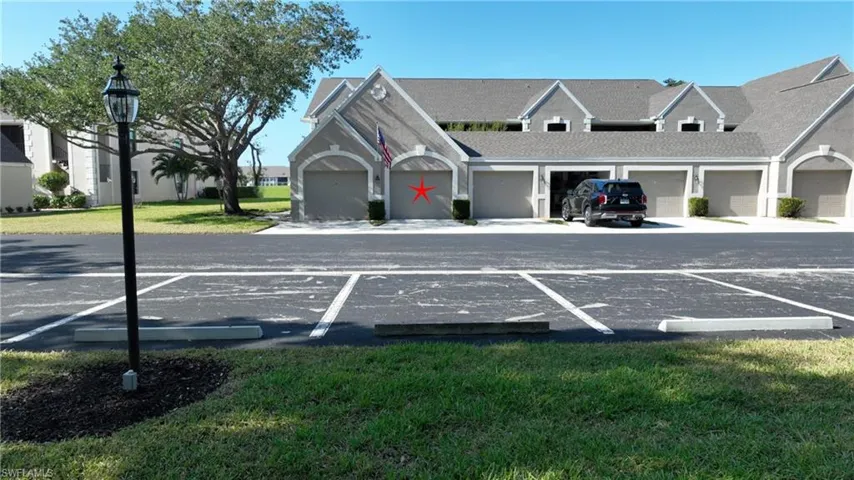 View of parking / parking lot featuring a lawn