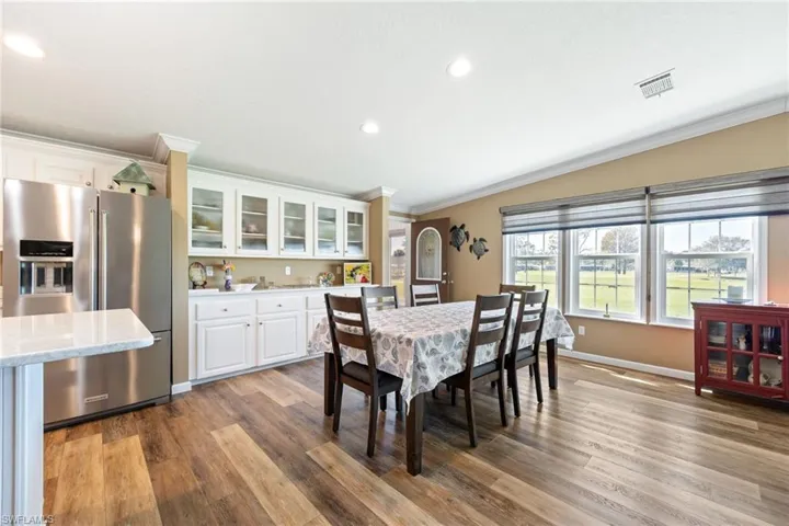 Dining room featuring ornamental molding, light wood-style flooring, and recessed lighting