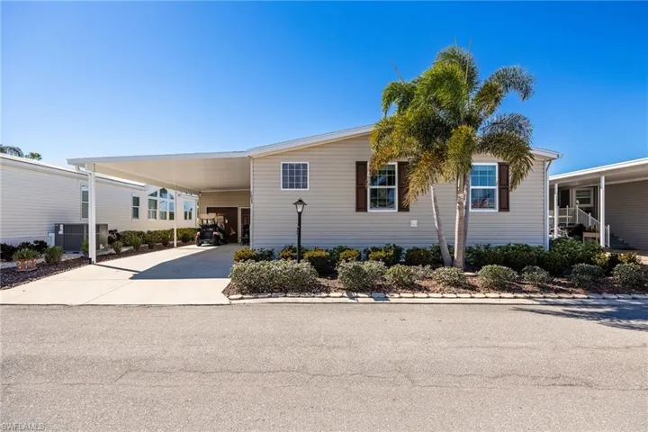 Manufactured / mobile home featuring an attached carport and concrete driveway