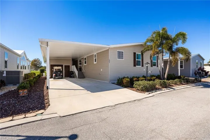 View of front facade with an attached carport and driveway