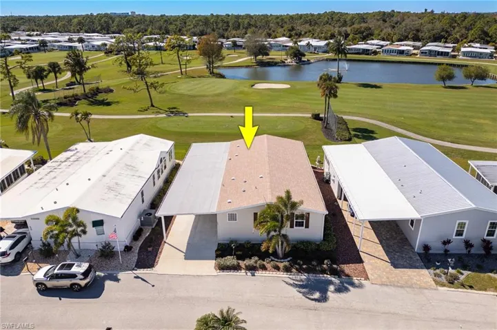 Aerial view of residential area with a golf club and a large body of water