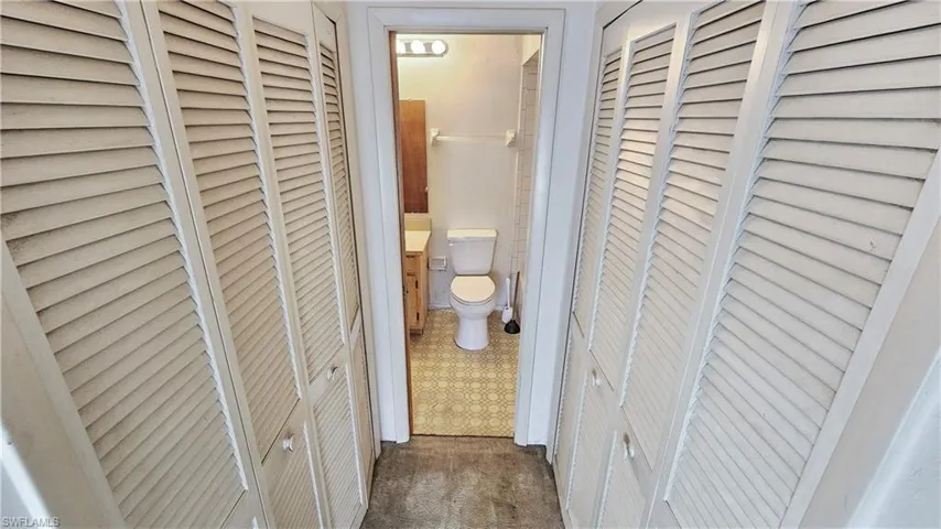 Hall featuring dark colored carpet