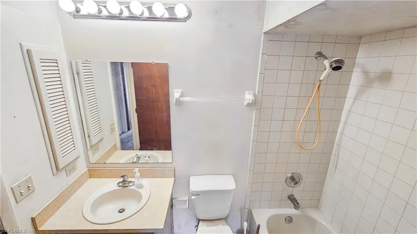 Full bathroom with tiled shower / bath, toilet, and vanity