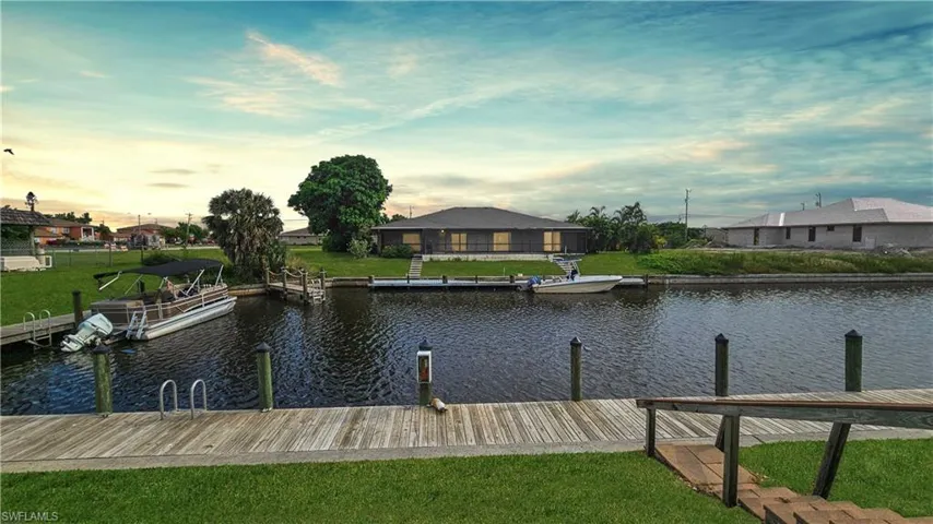 Dock area featuring a water view and a lawn