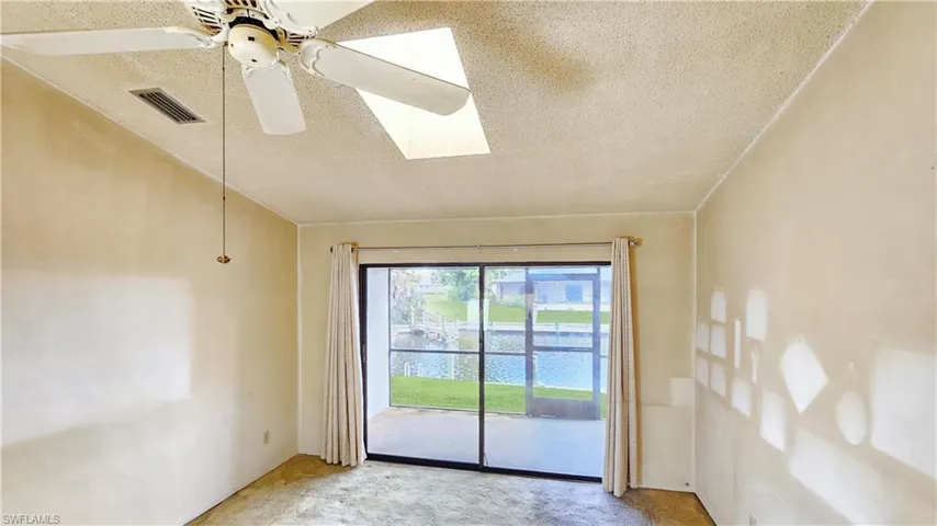 Carpeted empty room featuring ceiling fan and a textured ceiling