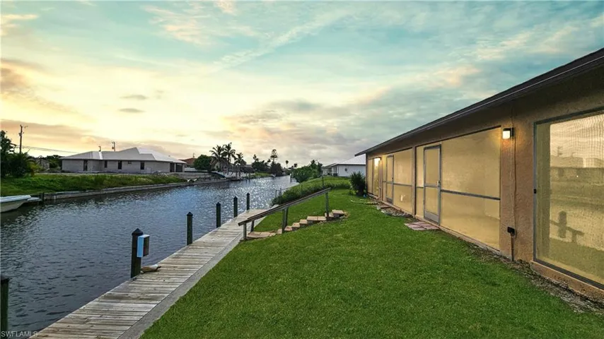 View of dock featuring a water view and a lawn