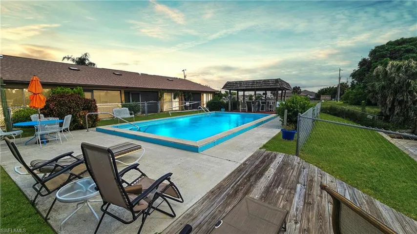 Pool at dusk featuring a pergola, a yard, and a patio area