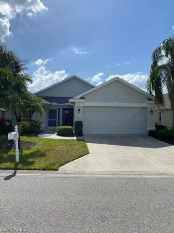 Ranch-style home featuring a garage, stucco siding, driveway, and a front yard