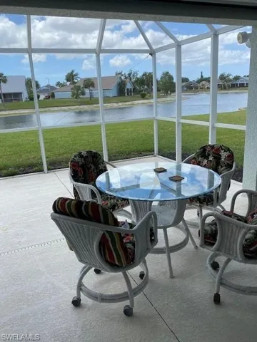 Sunroom / solarium featuring outdoor dining area, a water view, and a residential view