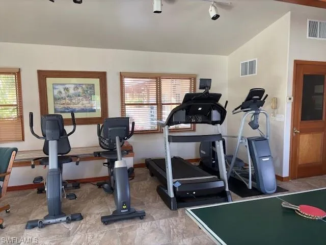 Workout area with lofted ceiling and rail lighting